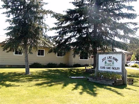 Exterior view of a single-story elder care facility with a Just Like Home sign.