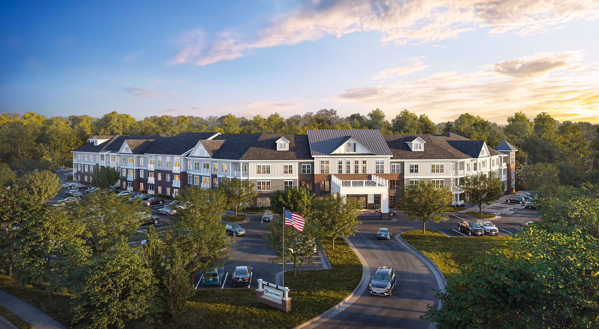 Exterior view of a large, three-story senior living facility named Lake Forest at Swift Creek, surrounded by trees and a parking lot with several cars. The building features a mix of white and brick facade with multiple windows and a prominent entrance with a covered porch. An American flag is displayed near the entrance, and the sky is partly cloudy with a warm sunset glow.