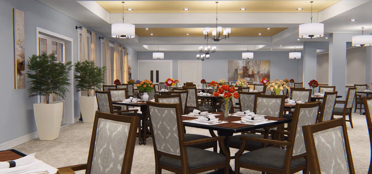 Spacious dining room with multiple set tables and chairs, floral centerpieces, pendant lights, and potted plants.