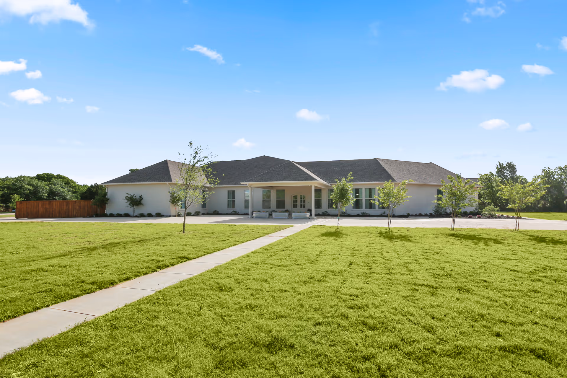 Single-story Oakview Assisted Living Memory Care facility with lawn, walkway, and trees.