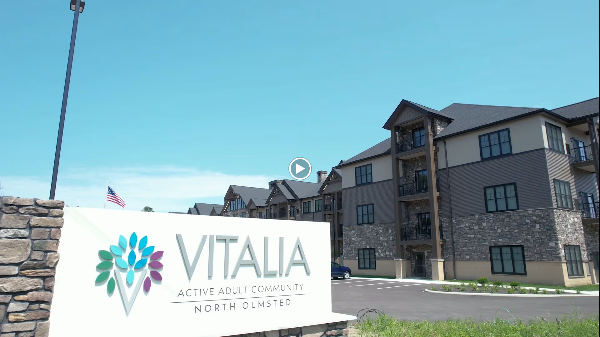 Entrance sign reading 'VITALIA Active Adult Community North Olmsted' in front of a multi-story residential building.