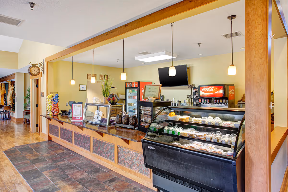Interior snack bar and beverage counter with glass display cases, pendant lights, and a Coca-Cola drink station.
