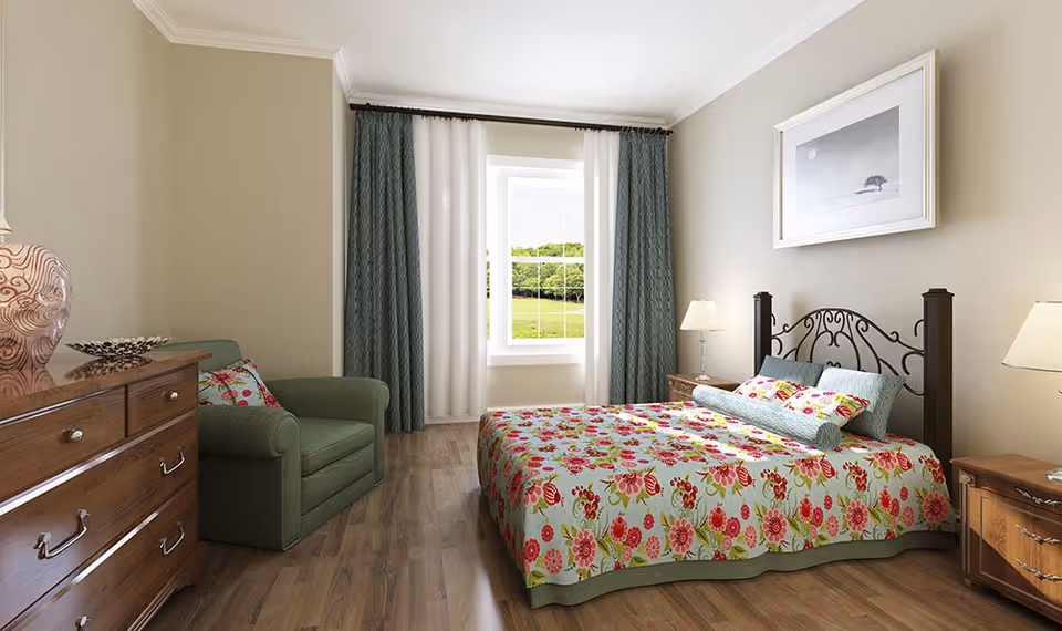 A cozy bedroom with a floral-patterned bedspread on a metal bed frame, two wooden nightstands with lamps, a green armchair, a wooden dresser with a decorative vase, and a window with green and white curtains overlooking a grassy landscape.