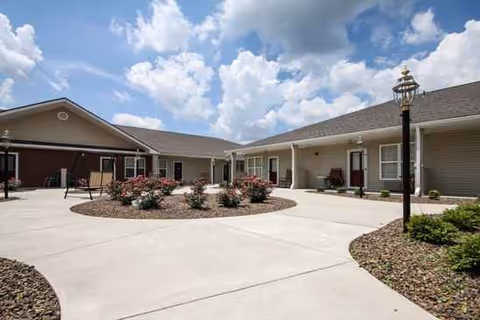 Exterior view of River Crossing senior living facility with a circular landscaped island and walkway.