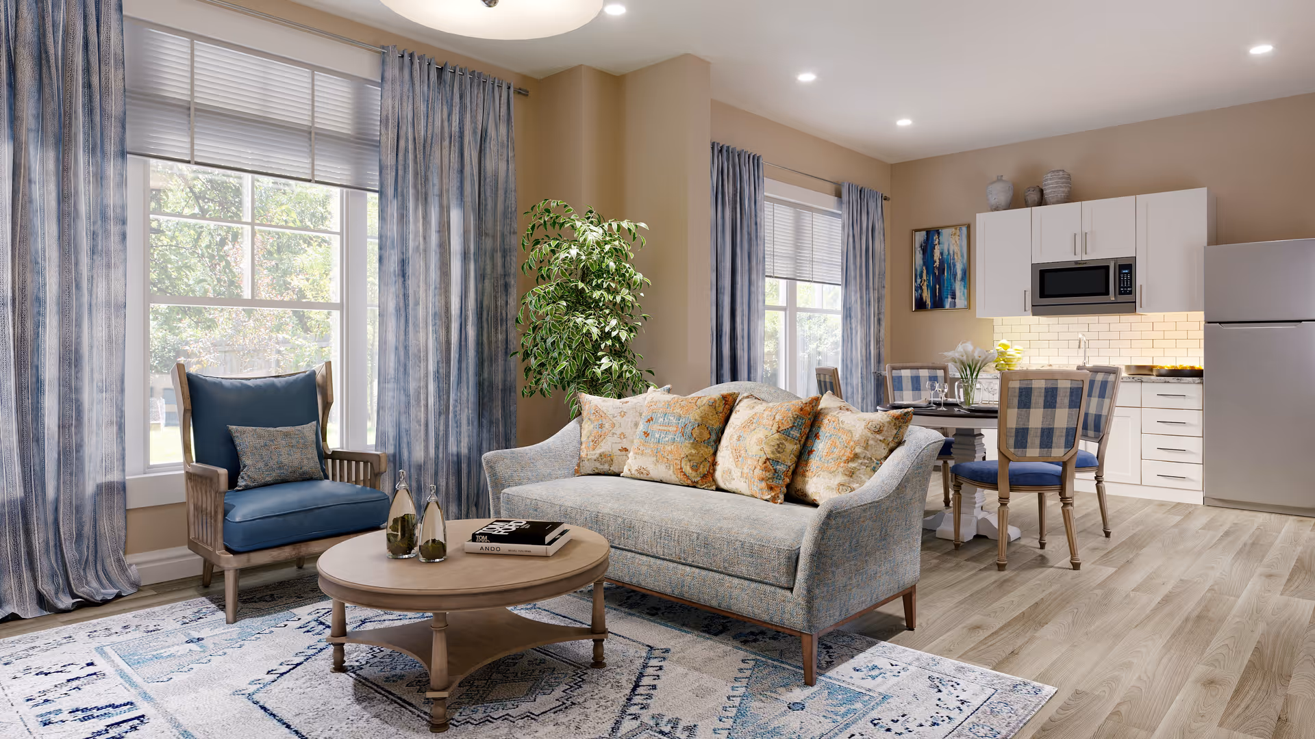 Bright open living area with a sofa, armchair, coffee table, dining set and a small kitchen under large windows with blue curtains.