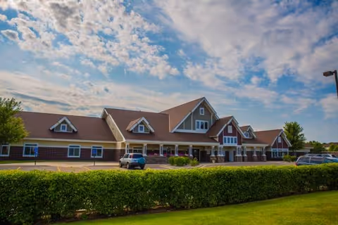 Front exterior of Encore Assisted Living and Memory Care at Champlin with a hedge