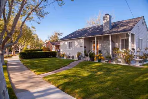 Single-story senior living facility with porch, walkway, and well-kept front lawn.