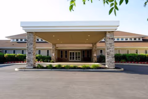 Front entrance of a senior living facility with a covered drop-off area.