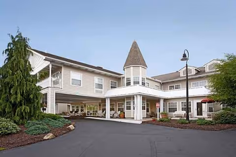 Exterior view of Newhaven Court at Clearview, a two-story senior living facility with turret and driveway.