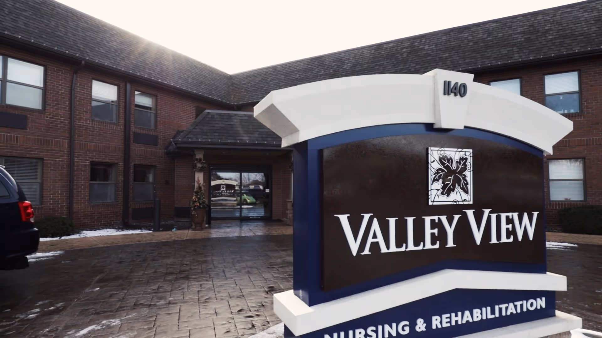 Exterior view of Valley View Nursing and Rehabilitation facility showing a large sign with the facility name and address number 1140 in front of a brick building with multiple windows and an entrance door.