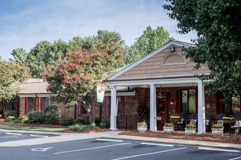 Exterior view of White Oak Manor Charlotte entrance with porch, columns, and landscaping.
