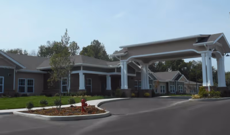 Front view of Mulberry Gardens Memory Care exterior with porte-cochere entrance and driveway