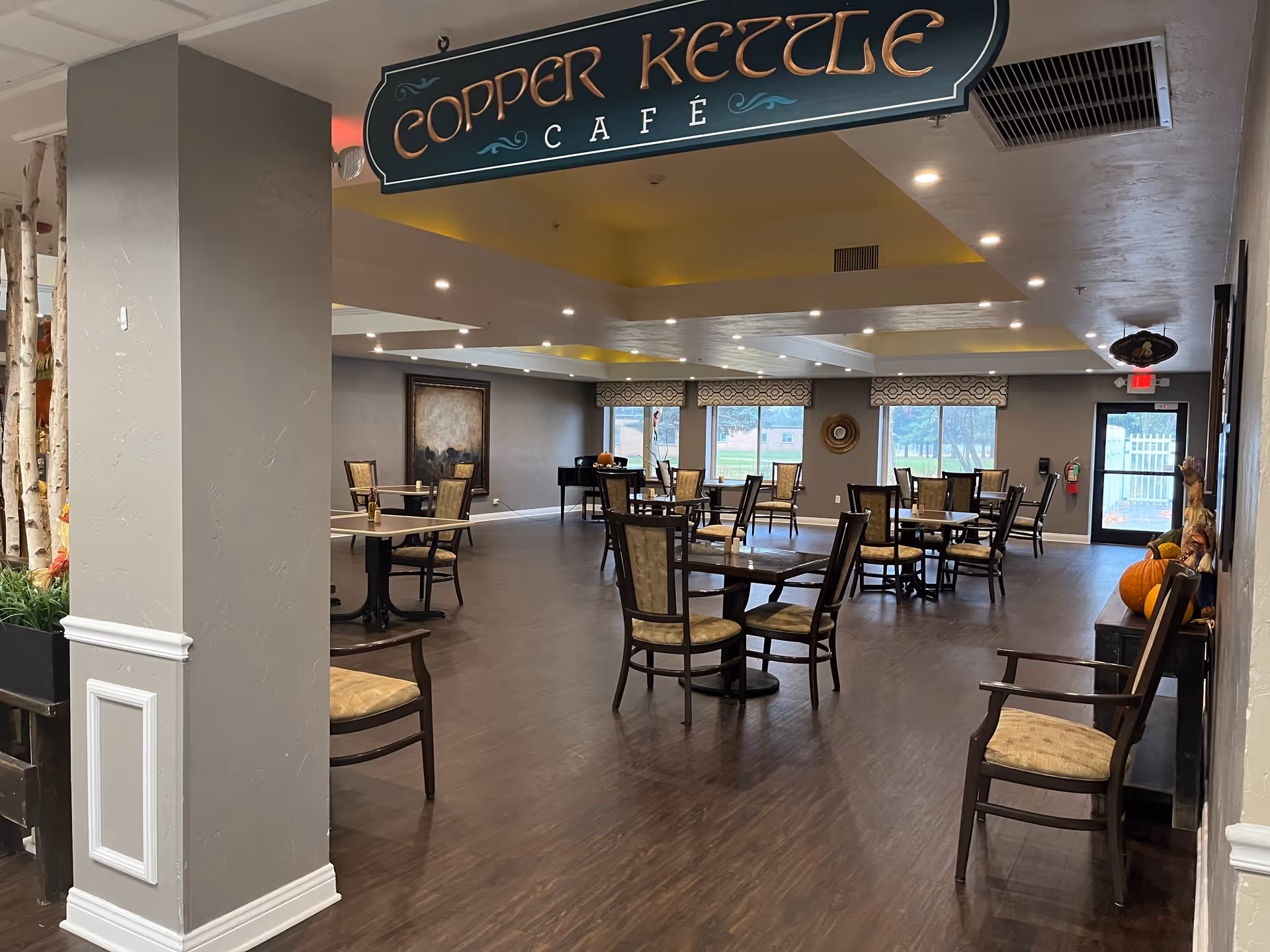 Dining room interior labeled "Copper Kettle Café" with multiple tables and chairs on dark wood flooring.