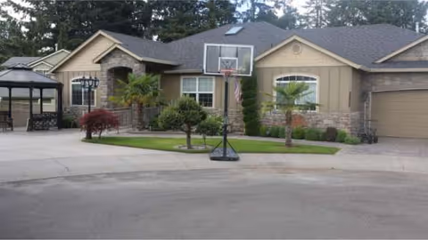 Front view of Mercy Family Home, a single-story facility with a yard, gazebo, and basketball hoop.