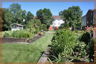 Well-maintained courtyard garden with raised flower beds, a gazebo, and surrounding apartment buildings.