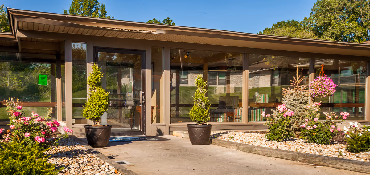 Exterior view of Warren Nursing & Rehab facility with landscaping and flowers.