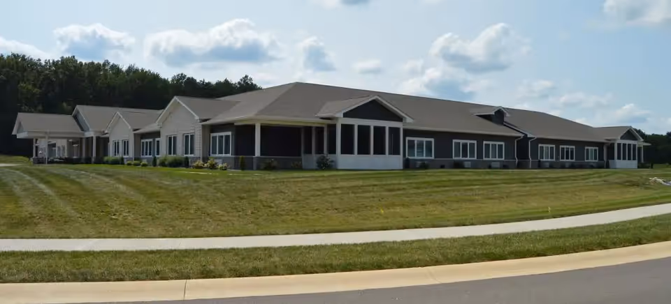 Single-story senior living facility with multiple wings and a curved front lawn.