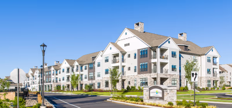 Exterior view of Covenant Living Cromwell senior living building with landscaping and entrance sign.