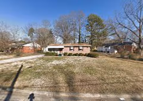 Front view of Worthdale Family Care Home, a single-story brick building with a front yard.