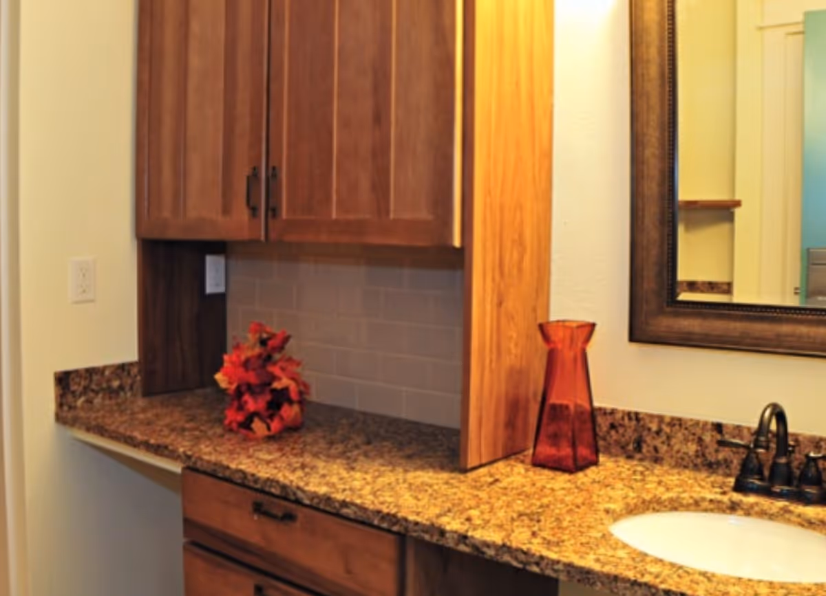 Kitchen workspace with granite countertops, wooden cabinets, and a sink.