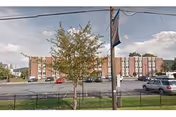 Exterior view of Cedarbrook Fountain Hill facility with brick building, flagpole, trees, and parked cars.