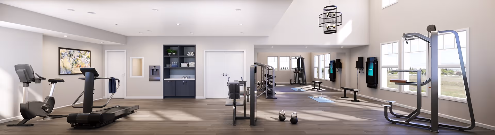 Bright, spacious fitness room with treadmills, exercise bikes, weight machines, kettlebells, and large windows.