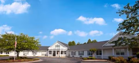 Brookdale Forest City exterior: single-story white building with a parking lot under blue skies