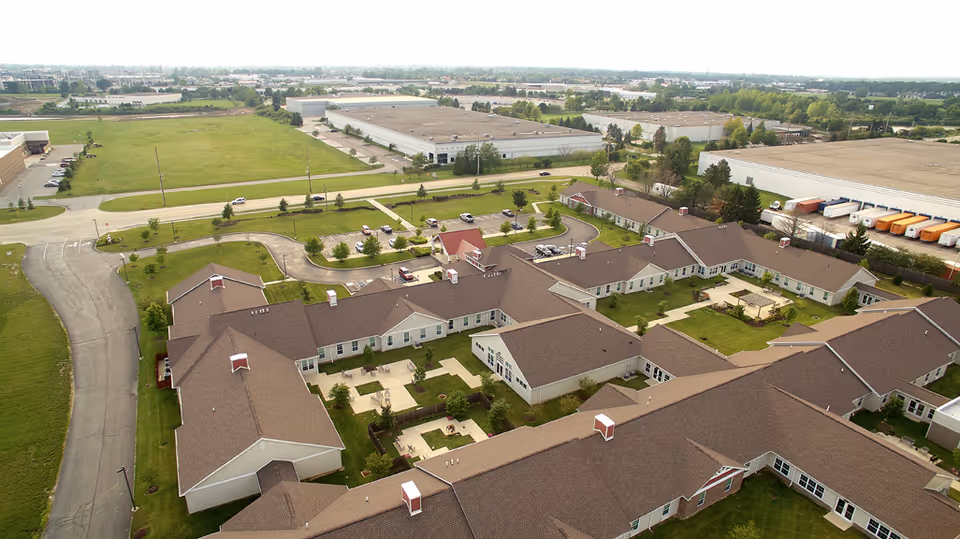 Aerial view of the Hamilton Trace senior living complex showing multiple single-story buildings, courtyards, driveways, and surrounding industrial lots.