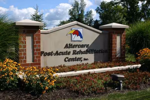 Exterior sign for Altercare Post-Acute Rehabilitation Center beside a flower bed.