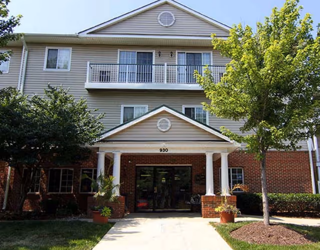 Bay Forest senior living building exterior with brick entrance and balconies.
