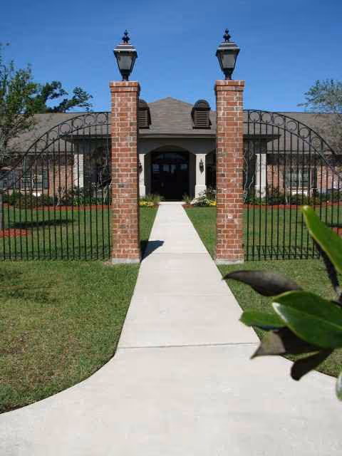 Brick entry gates open to the front entrance of a senior living facility.