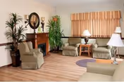 Cozy Haven Health Prescott living room lounge with couches, chairs, fireplace, plants, and lamps.