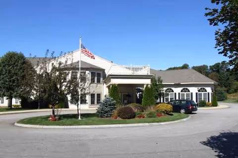 Exterior view of Benchmark at Haverhill Crossings with flagpole, landscaping, and parked car.