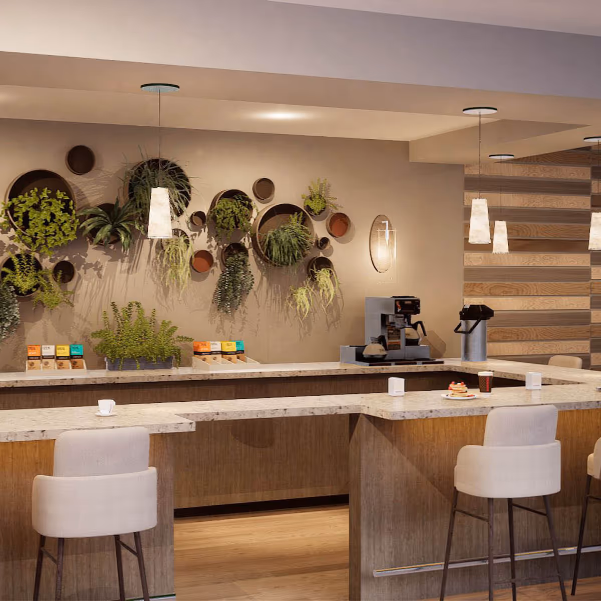 A modern coffee bar area with a marble countertop and wooden base, featuring two beige upholstered bar stools. The back wall has circular wall-mounted planters with various green plants. There is a coffee machine and a thermal carafe on the counter, along with a cup, a plate with pancakes, and a takeaway coffee cup. Pendant lights hang from the ceiling, and the wall on the right has a wooden panel design.