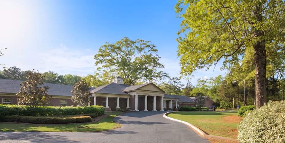 Front exterior view of The Fairways at Grayson Valley with curved driveway and trees
