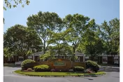 Front exterior view of Queen Anne Nursing Home building surrounded by trees and landscaping with a sign in front displaying the facility name.
