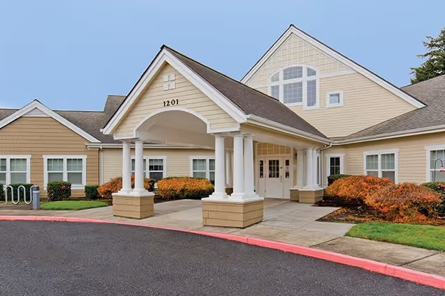 Exterior view of Brookdale Troutdale's front entrance with columns and landscaping.