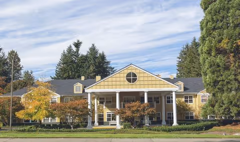 Front view of The Sequoia Assisted Living Community building with columns and trees.