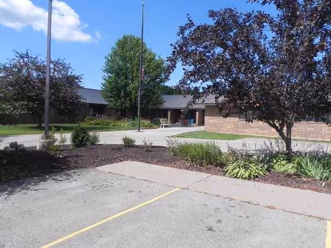 Front exterior of Vernon Manor senior living facility with entrance and landscaped walkway.