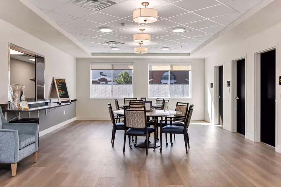 Bright, modern indoor dining area with a round table and chairs near large windows.
