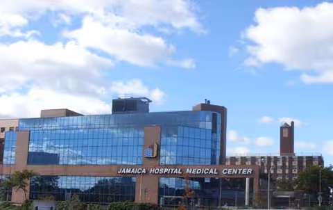 Exterior view of Jamaica Hospital Medical Center building with blue glass facade.