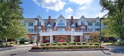 Front view of Juniper Village at Paramus, a multi-story senior living building with landscaped entrance.