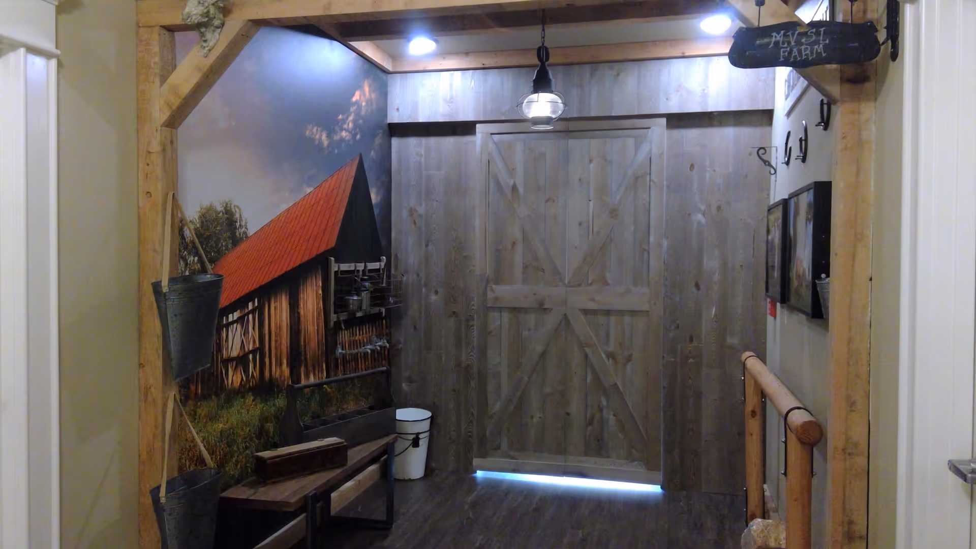 Interior rustic corridor featuring a large wooden barn-style sliding door, a barn mural on the left, and farmhouse decor.