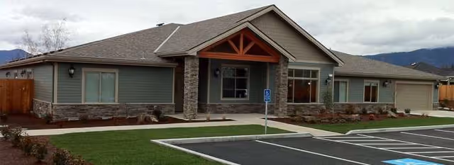 Front exterior of Applegate House of Grants Pass senior living facility with parking