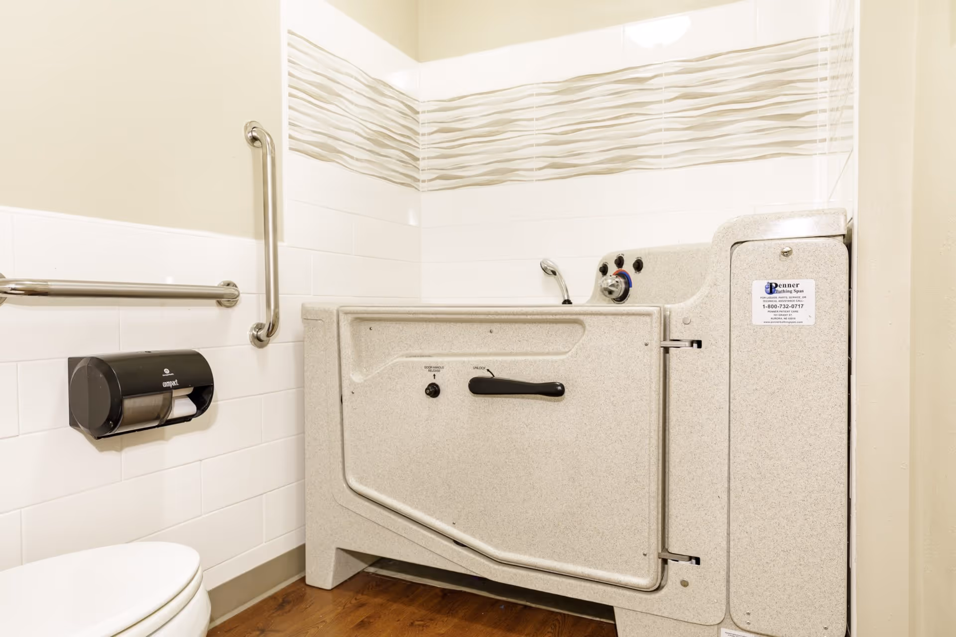 Accessible bathroom featuring a walk-in tub with a door, grab bars, and a toilet.