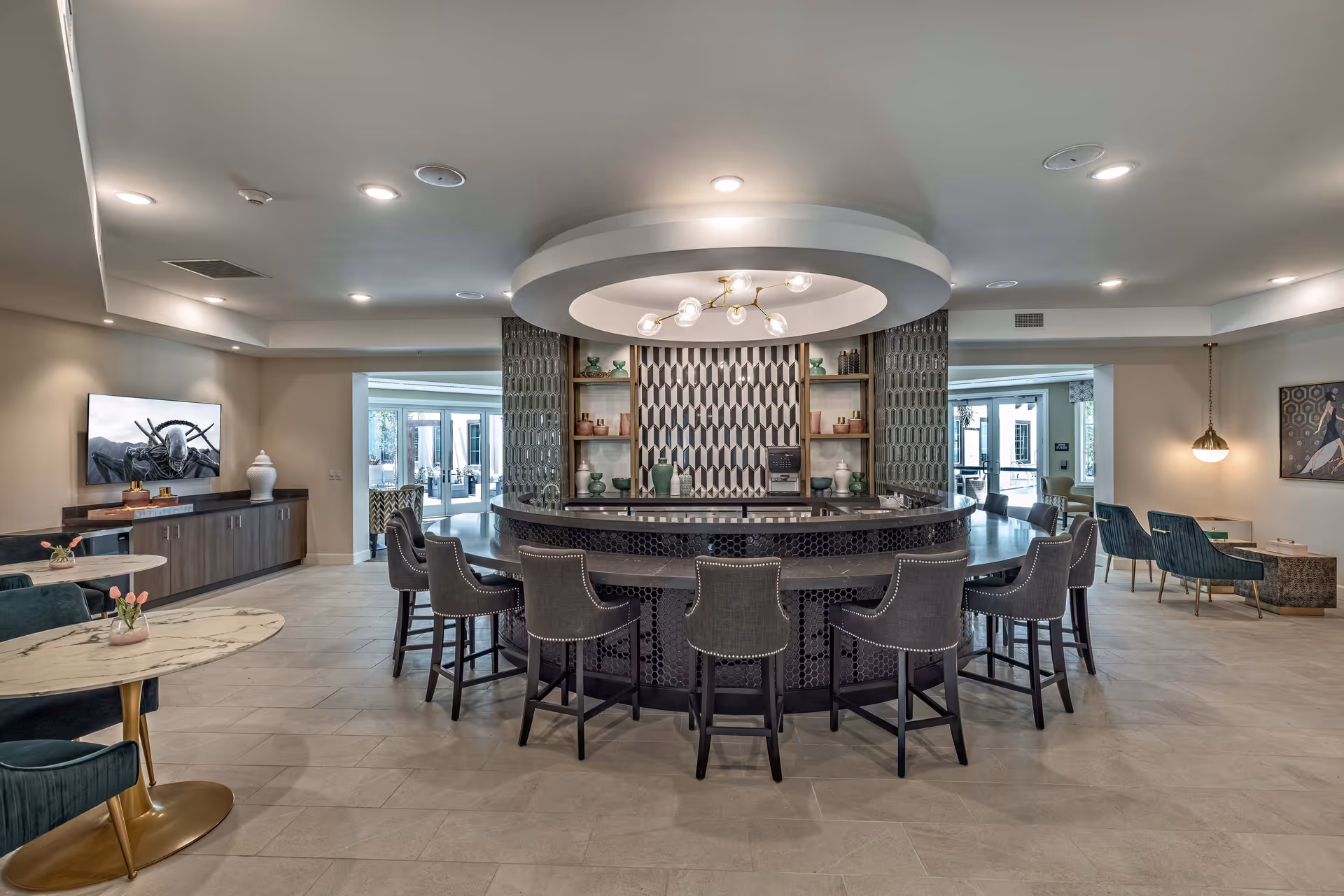 Spacious interior common area with a circular central bar surrounded by stools and multiple seating and dining areas.