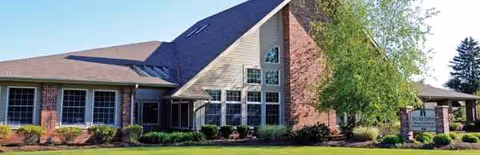 Exterior view of Rae-Ann Geneva Nursing and Rehabilitation building with brick facade and landscaping