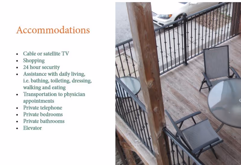 A balcony or outdoor patio area with a round glass table and three chairs, wooden flooring, and black metal railing. A parking lot with cars is visible beyond the railing. On the left side, text lists accommodations including cable or satellite TV, shopping, 24 hour security, assistance with daily living, transportation to physician appointments, private telephone, private bedrooms, private bathrooms, and elevator.