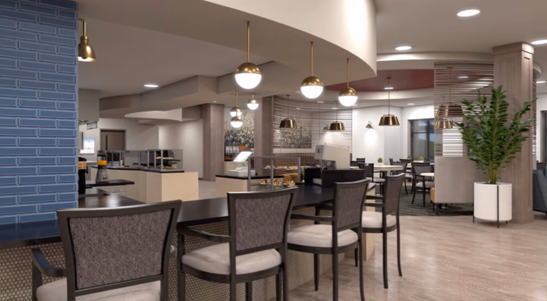 Interior view of a modern dining area in a senior living facility with a long counter and several chairs, pendant lights hanging from the ceiling, tables and chairs in the background, and a large potted plant near a wooden column.