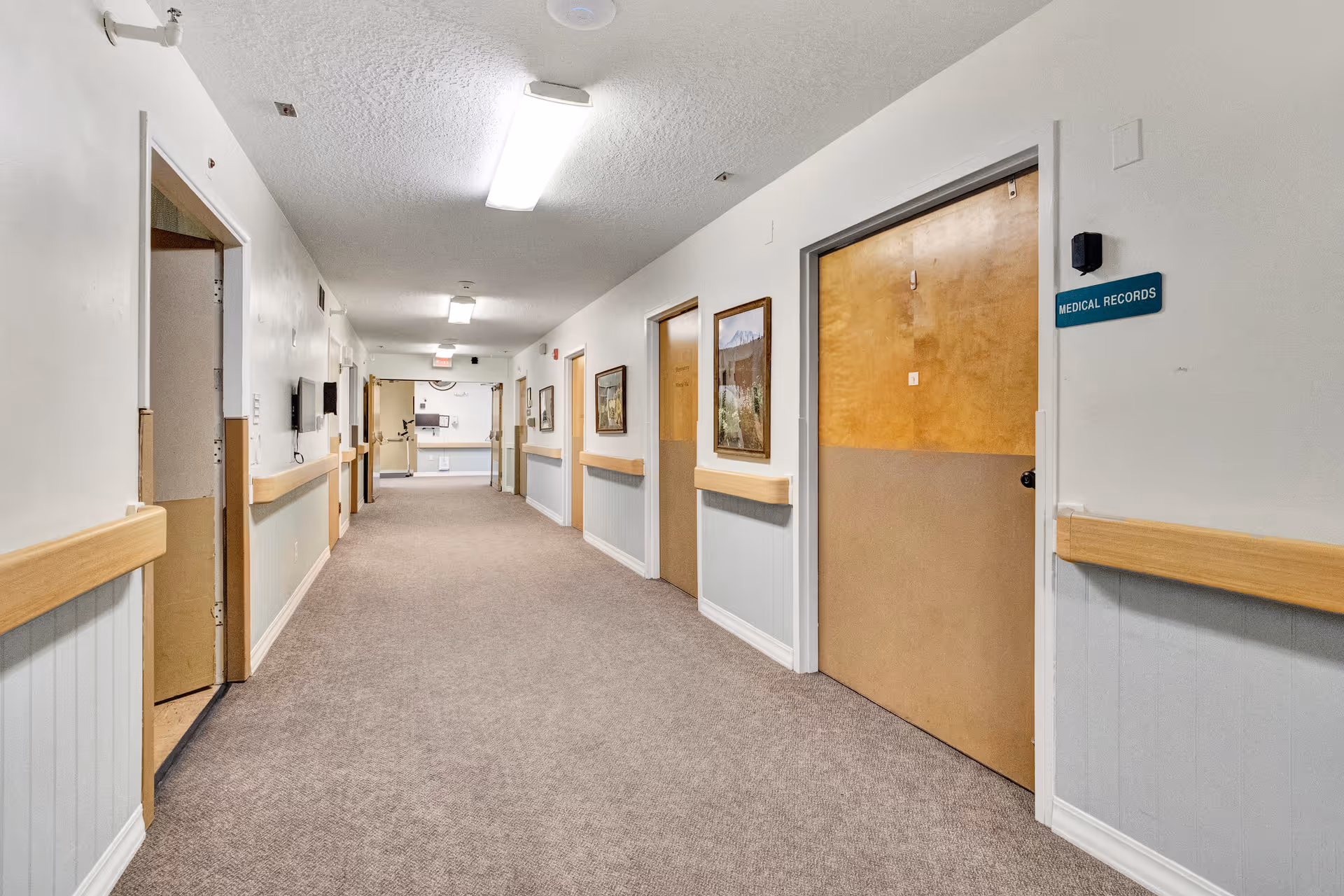 Carpeted interior hallway with doors on both sides and a 'Medical Records' sign on the right.